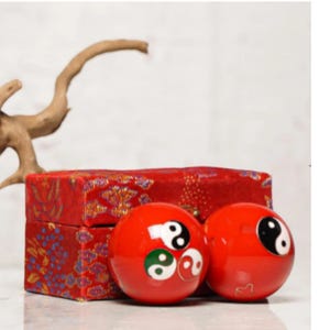 May include: A white ceramic mug with a black handle and the text "But First, Coffee" in a bold, black font. The mug is on a wooden surface. The mug is approximately 10 cm tall.