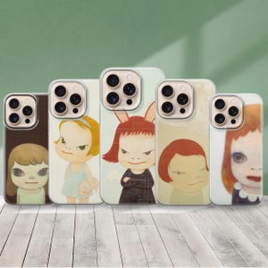 May include: Five phone cases with unique illustrations of cartoon-style girls. The cases feature different color schemes, including brown, light blue, and red. Each case has a clear protective bumper around the phone.