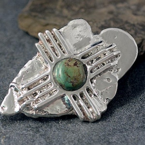 Corbata bolo de plata esterlina, fundida en arena orgánica, con cruz de Nuevo México y piedra turquesa de Sonora, estilo suroeste.