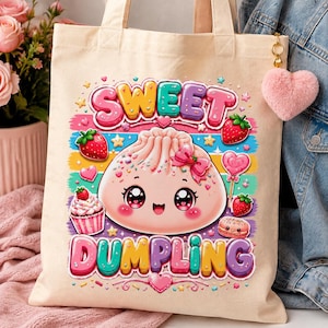 May include: A beige canvas tote bag featuring a colorful graphic of a smiling pink dumpling with large eyes and a bow. The text reads SWEET DUMPLING in bubble letters, surrounded by strawberries, a cupcake, a macaron, and a pink heart keychain.