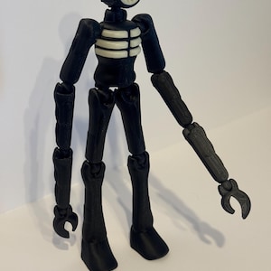 May include: A black and white articulated Siren Head figure. The figure has a cylindrical head with a speaker-like design, a white rib cage, and jointed limbs. The figure is standing on a white surface.