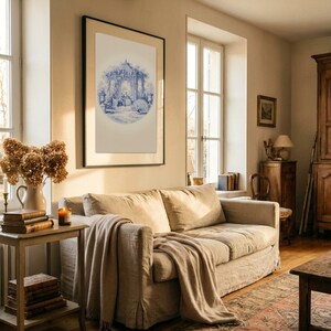 May include: A comfortable living room with a beige sofa and a throw. A framed blue and white print is on the wall. A side table displays books, dried flowers in a vase, and a candle. The room has a patterned rug and wooden flooring. The room is bathed in natural light.