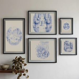 May include: A collection of five framed prints with blue and white illustrations of garden scenes. The prints are in black frames, arranged on a white wall. The artwork includes depictions of architectural elements. A shelf with decorative items is positioned below the framed prints.