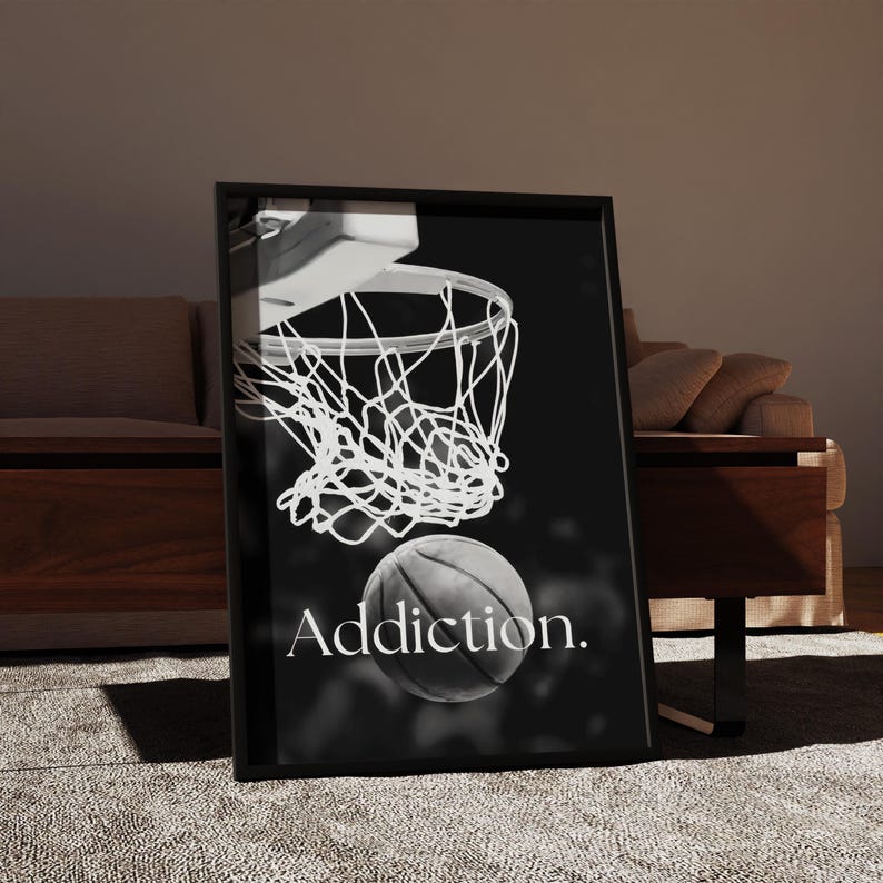 May include: Black and white framed print featuring a basketball net and ball. The word "Addiction" is printed below the ball. The image is set against a dark background.
