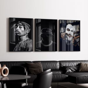 以下が含まれることがあります： 3つの白黒フレーム入りウォールアートプリントのセット。プリントには、バンダナを着用した人、バケットハットを着用した人、白いバラクラバを着用した人など、個人の肖像画が描かれています。