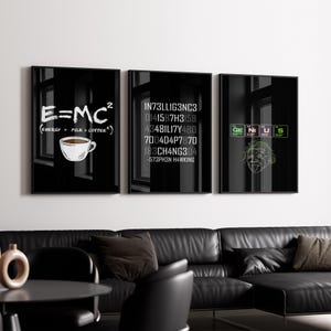 May include: Three black framed wall art pieces. The left panel features the equation E=MC² with a coffee cup illustration. The center panel displays a series of numbers and the name Stephen Hawking. The right panel shows the word "GENIUS" and an Einstein illustration.