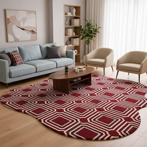 Könnte beinhalten: Ein Wohnzimmer mit einem hellblauen Sofa, zwei beigefarbenen Sesseln und einem ovalen Couchtisch aus dunklem Braun. Ein rot-weiß gemusterter Teppich bedeckt den Boden. Ein Bücherregal aus Holz und ein gerahmtes abstraktes Gemälde sind ebenfalls zu sehen.