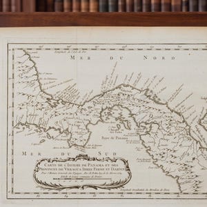 Może przedstawiać: Zabytkowa czarno-biała mapa Przesmyku Panamskiego oraz prowincji Veragua, Tierra Firme i Darien. Mapa zawiera szczegółowe linie brzegowe, oznaczenia geograficzne w języku francuskim oraz ozdobny kartusz z tytułem.