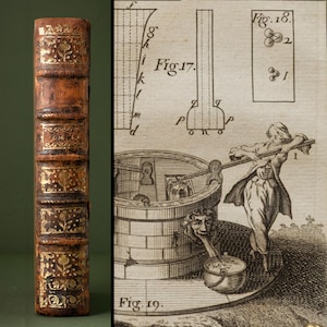 Könnte beinhalten: Ein brauner Buchrücken aus Leder mit goldgeprägten Blumenmustern und Bünden, neben einem antiken schwarz-weißen Stich, der einen Steinbrunnen, eine Person an einem Hebel sowie technische Diagramme mit der Beschriftung Fig. 17 und 18 zeigt.