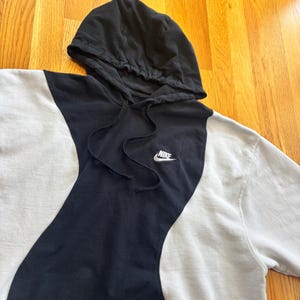 May include: A white ceramic mug with a black handle and the text "But First, Coffee" in a black, handwritten-style font. The mug is on a white surface.