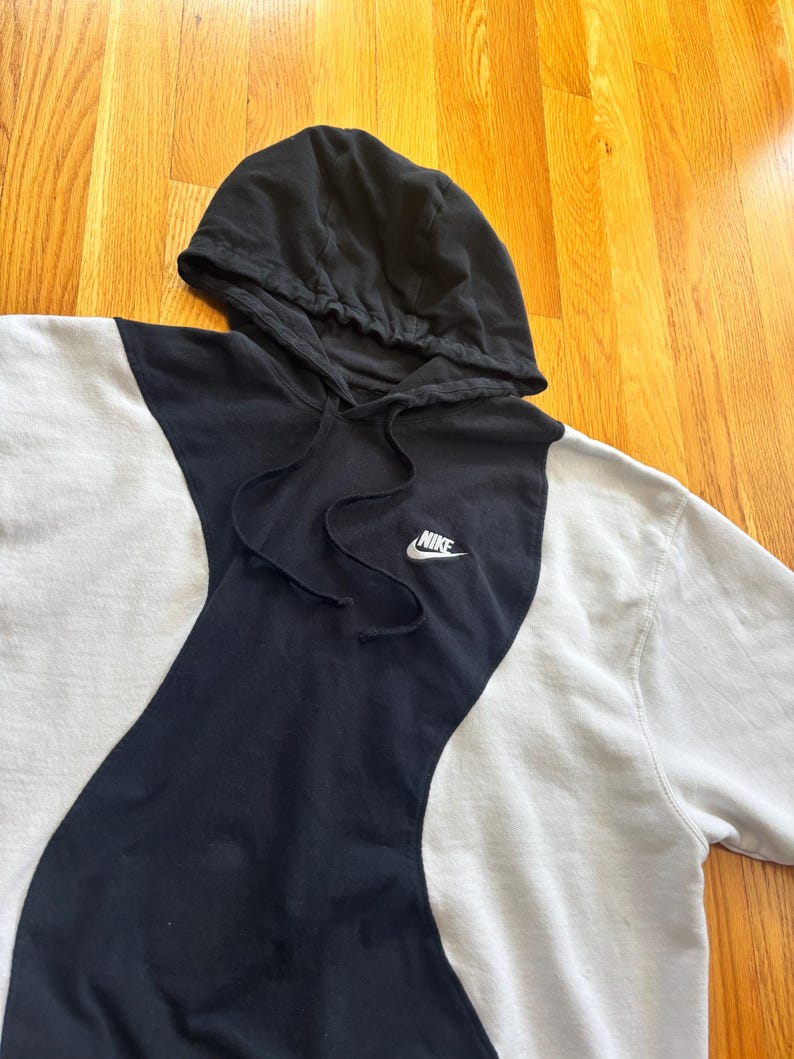 May include: A white ceramic mug with a black handle and the text "But First, Coffee" in a black, handwritten-style font. The mug is on a white surface.