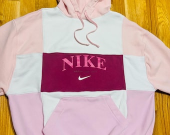 Sudadera con capucha reciclada Nike con parche rosa.