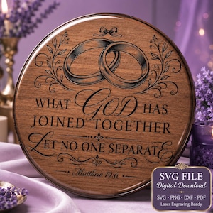Könnte beinhalten: Eine runde Holzplatte mit einer Lasergravur von zwei ineinander verschlungenen Eheringen oben. Der Text lautet: WHAT GOD HAS JOINED TOGETHER LET NO ONE SEPARATE, gefolgt von Matthew 19:6. Das Design enthält dekorative Schnörkel.