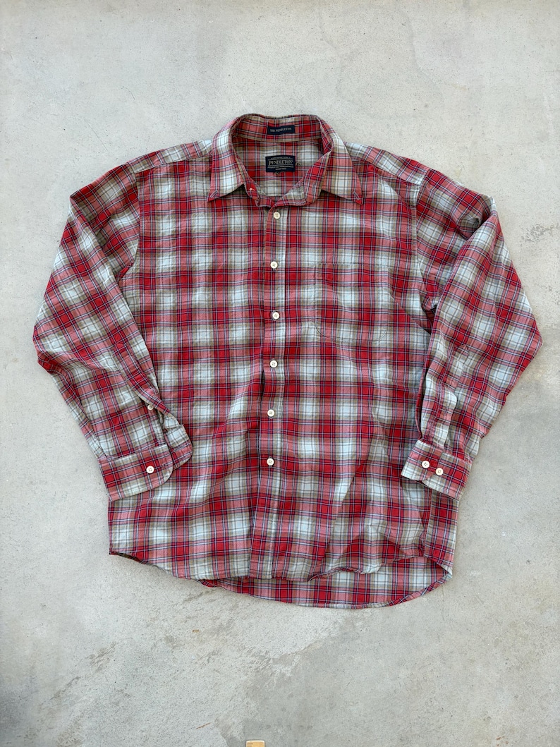 Puede incluir: Camisa a cuadros rojos y blancos con mangas largas. La camisa tiene un cuello cl&aacute;sico y pu&ntilde;os abotonados. El patr&oacute;n de cuadros incluye l&iacute;neas azul claro y blancas. La camisa est&aacute; hecha de una tela suave y tejida.