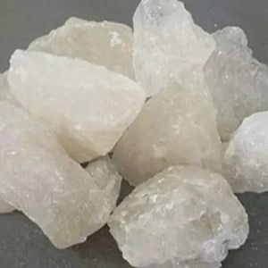 May include: A pile of translucent, irregularly shaped, crystalline rocks. The rocks have a slightly frosted appearance and vary in size, with some appearing larger than others. The overall color is a pale, off-white.