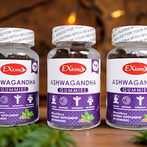 May include: Three clear plastic bottles of Ashwagandha Gummies. Each bottle has a white label with the brand name "Exione" and the product name. The label also includes the words "Relax, Restore, Strength, De-Stress". The bottles are filled with dark brown gummies.