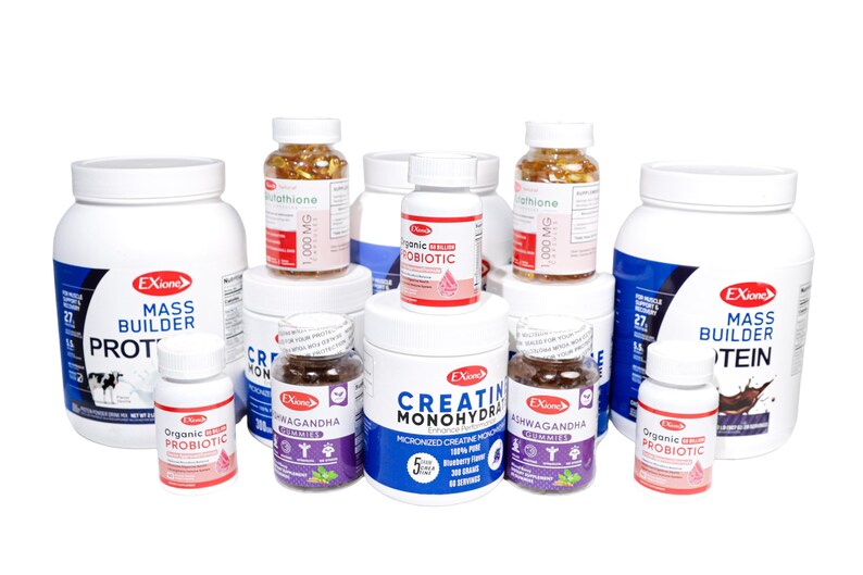 May include: A selection of white supplement bottles and jars with blue and red labels. Products include Mass Builder protein powder, Creatine Monohydrate, and Organic Probiotic. Some bottles contain capsules or gummies.