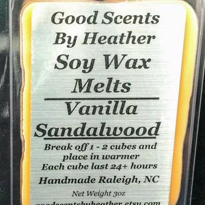 May include: A close-up of a small, clear plastic container with a yellow soy wax melt inside. The wax melt is labeled "Good Scents By Heather Soy Wax Melts Vanilla Sandalwood". The label also includes instructions for use and the text "Handmade Raleigh, NC" and "Net Weight 3oz".