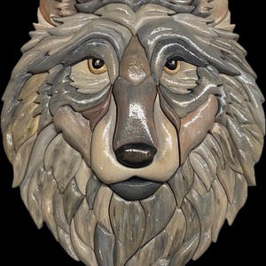 May include: A detailed wooden carving of a wolf's head, featuring a mosaic-like design. The artwork showcases a range of neutral tones, including gray, brown, and beige, with a glossy finish. The wolf's eyes are a warm amber color, and the background is black.