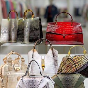 May include: A collection of various leather handbags in different colors and styles. The bags feature textured surfaces, including crocodile and snake patterns. Colors range from red and white to black and green, with gold-toned hardware and handles.