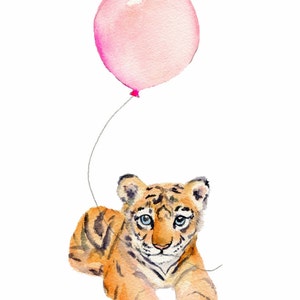 May include: A watercolor painting of a cute tiger cub holding a pink balloon. The tiger cub is looking at the viewer with big blue eyes. The background is white.