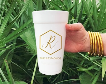 May include: White foam cup with a gold hexagonal design featuring the letter "R" and the text "THE RAYMONDS".
