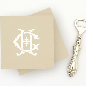 May include: Tan square cards with a white monogram and a silver bottle opener. The monogram features the letters "C" and "H" intertwined. The bottle opener has a decorative handle.