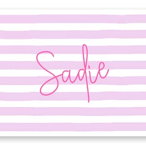 May include: Pink and white striped background with the name Sadie written in pink cursive.