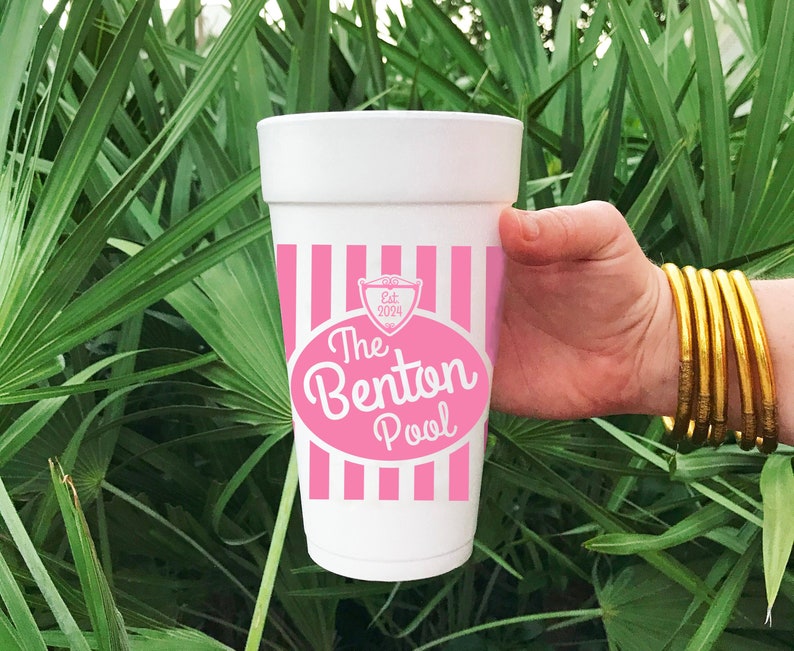 May include: A white foam cup with pink and white stripes and the text "The Benton Pool Est. 2024" in a pink oval.