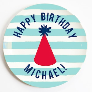 K&ouml;nnte beinhalten: Ein blauer und wei&szlig; gestreifter Pappteller mit dem Text "Happy Birthday Michael!" in dunkelblauer Schrift. In der Mitte des Tellers befindet sich eine rote Partym&uuml;tze mit einem blauen Bommel.