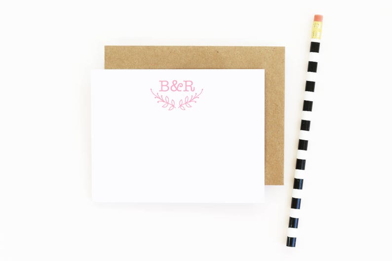 May include: A white card with a pink floral design and the text "B&R" in the center.