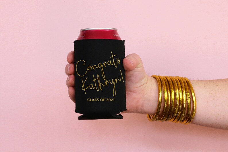 May include: Black can cooler with gold lettering that says "Congrats Kathryn! Class of 2021".