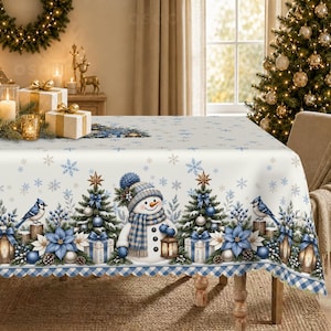 May include: A white rectangular tablecloth featuring a repeating Christmas pattern of snowmen wearing blue plaid scarves and hats, decorated pine trees, blue poinsettias, blue jays, and light blue snowflakes, finished with a blue and white chequered border.