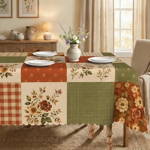 May include: A rectangular tablecloth featuring a patchwork design of alternating squares in shades of sage green, cream, and burnt orange. The pattern includes floral motifs, a small grid print, and a classic gingham check with a scalloped edge.