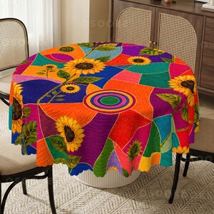 Peut inclure: Une nappe ronde présentant un motif géométrique multicolore vibrant avec de grands tournesols jaunes, des feuilles vertes et des cercles concentriques dans des tons de bleu, orange, violet et sarcelle, finie avec un bord festonné.