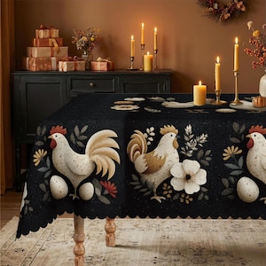 May include: A black tablecloth featuring a repeating pattern of white roosters, speckled eggs, and white flowers with green leaves. The fabric has a scalloped edge and covers a table, creating a decorative display with lit candles and gifts.