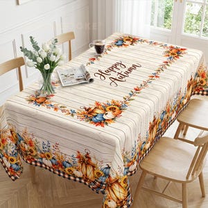 May include: A rectangular tablecloth featuring a white wood-plank pattern with the text Happy Autumn in black script. The design includes borders of sunflowers, pumpkins, blue gourds, and lanterns in orange, yellow, and blue hues.
