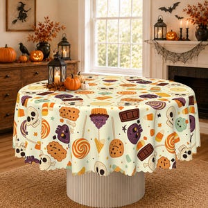 May include: A round tablecloth featuring a repeating pattern of Halloween-themed icons including skulls, cupcakes, lollipops, chocolate bars, and candy corn on a cream-colored background. The design includes orange, purple, and brown accents.
