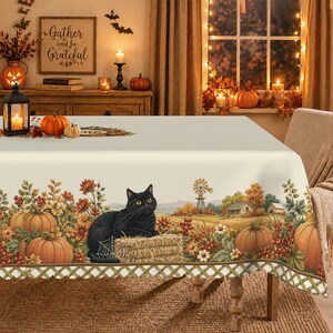 May include: A rectangular tablecloth featuring a cream-colored center and a decorative border displaying a black cat sitting on a hay bale, orange pumpkins, autumn foliage, a windmill, and farm buildings, finished with a green lattice trim.