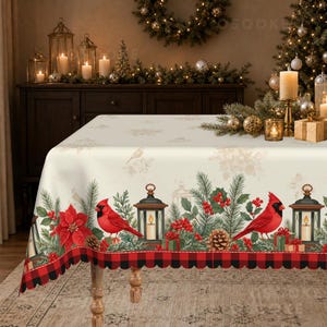 May include: A rectangular tablecloth featuring a cream-coloured background with a festive border print. The design includes bright red cardinals, green pine branches, red poinsettias, lanterns, and gifts, finished with a red and black buffalo plaid edge.