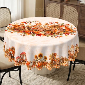 May include: A round tablecloth featuring a cream-coloured background with a vibrant autumn-themed print. The design includes illustrations of squirrels, rabbits, foxes, hedgehogs, pumpkins, sunflowers, and mushrooms in shades of orange, brown, and yellow.