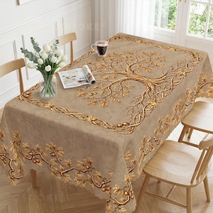 Peut inclure: Une nappe rectangulaire beige ornée d'un grand motif central d'arbre doré avec des branches, des feuilles et des glands détaillés. La bordure présente un motif de vigne dorée en continu. Un vase en verre avec des tulipes blanches et un livre ouvert.