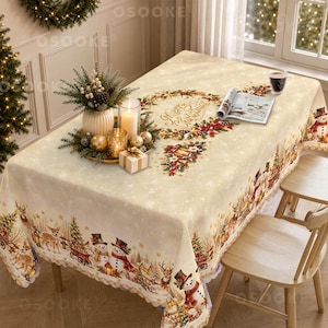 May include: A rectangular cream-coloured tablecloth featuring a festive Christmas print with snowmen, deer, and pine trees along the edges. The centre displays a wreath design with the text Merry Christmas, accented by a candle centrepiece and an open book.