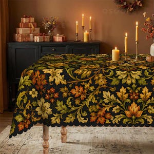 May include: A rectangular tablecloth featuring a black background with a repeating pattern of autumn leaves in shades of orange, yellow, and green. The fabric has a scalloped edge and covers a table, with lit candles and gift boxes visible nearby.
