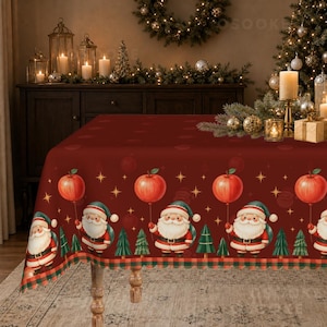 May include: A deep red rectangular tablecloth featuring a repeating pattern of Santa Claus figures holding red balloons, interspersed with small green pine trees and gold star accents, finished with a checkered border along the bottom edge.