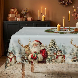 Könnte beinhalten: Eine rechteckige Tischdecke mit einer festlichen Winterszene, die den Weihnachtsmann, Rentiere und Schneemänner zeigt. Das Design umfasst verschneite Tannenbäume, verpackte Geschenke und ein zentrales Weihnachtskranzmotiv auf hellblauem Grund.