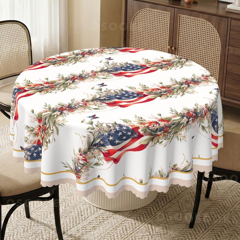 Pu&ograve; includere: Una tovaglia rotonda con sfondo bianco caratterizzata da un motivo ripetitivo di bandiere americane drappeggiate intrecciate con fogliame verde, fiori rossi e piccole farfalle blu. Il tessuto presenta un bordo smerlato con una sottile bordatura dorata.
