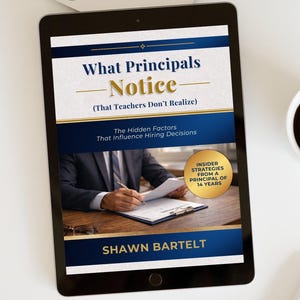 May include: A digital tablet displays the book cover "What Principals Notice (That Teachers Don't Realize)" by Shawn Bartelt. The cover features a person in a suit writing on a document. A cup of coffee sits to the right.