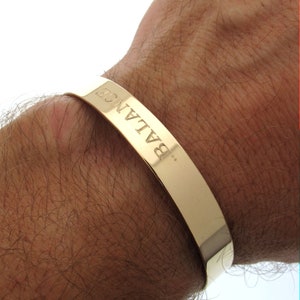 Puede incluir: Pulsera de oro con la palabra "BALANCE" grabada.