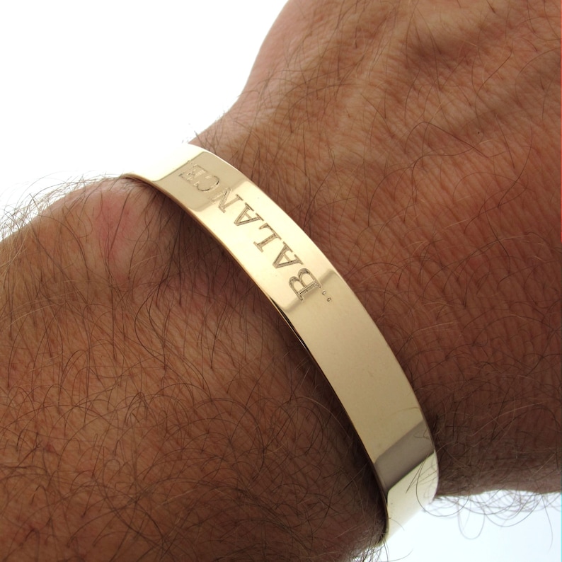 Puede incluir: Pulsera de oro con la palabra "BALANCE" grabada.
